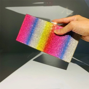 Close-up of rainbow gradient rhinestone clutch bag held by hand for luxury evening style