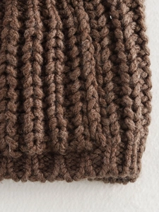 Macro shot of brown chunky knit fabric texture showing wool blend material details