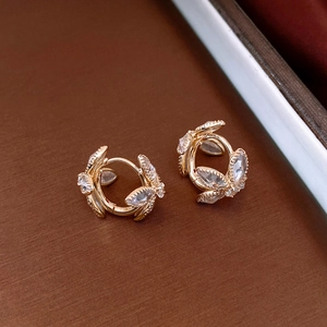 Macro view of gold flower hoop earrings with sparkling cubic zirconia floral details