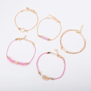 Close-up of a 5-piece gold bracelet set with pink beads, heart charms and infinity symbol