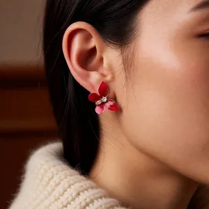 Boucles d'oreilles papillon rouge vintage avec zircon sur mannequin en pull crème