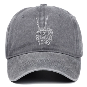 Detail of grey embroidery with skull hand and Good Vibes text on a washed baseball cap