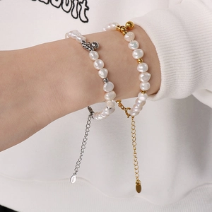 Détail de bracelets en perles d'eau douce dorés et argentés avec chaînes ajustables