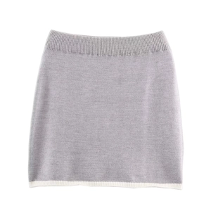 Dettaglio mini gonna grigia in maglia con bordo bianco ed elastico in vita a costine
