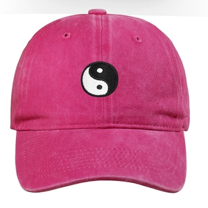 Close-up of Tai Chi Yin Yang embroidery on a magenta washed cotton baseball cap
