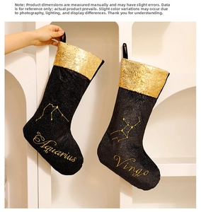 Close-up of black Christmas stockings with golden Aquarius and Virgo constellation embroidery