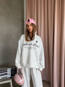 Grey half-zip sweatshirt set and pink baseball cap with football shaped bag
