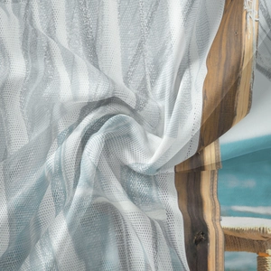 Detail of bohemian tapestry fabric showing mesh texture and tropical beach landscape