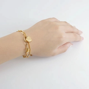 Detail of double-layer gold titanium steel heart bracelet on a female wrist