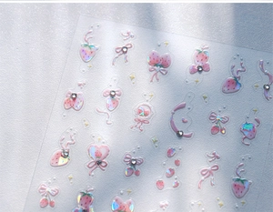 Macro view of transparent nail stickers with pink butterfly bows and tiny rhinestones
