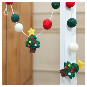 Detail of wool felt Christmas garland with pine tree and colorful balls on door frame