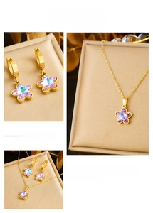 Close-up of gold-plated stainless steel jewelry set with purple crystal star charms