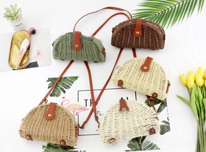 Detail showing five colors of semi-circle straw crossbody bags with leather flaps