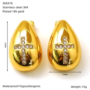 Vue détaillée des boucles d'oreilles goutte dorées 18k avec détails en croix et specs