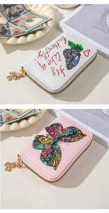 Detailed view of embossed butterfly patterns and clover metal zipper on PU leather wallet