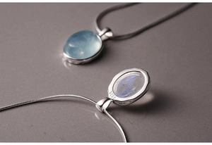 Macro shot of S925 silver necklace featuring an oval aquamarine pendant with hollow back