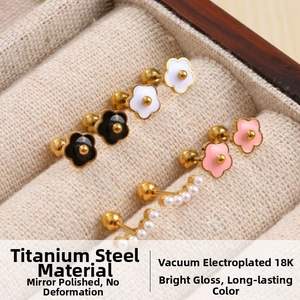 Detail of 18K gold-plated titanium steel floral and pearl stud earrings set in a box