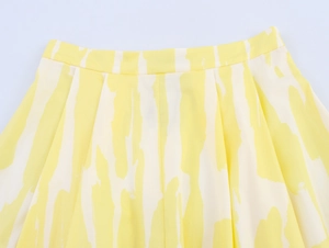 Close-up of high-waist yellow and white abstract floral midi skirt with pleated texture