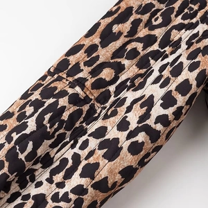 Detailed view of leopard print fabric and quilted texture on a lightweight jacket