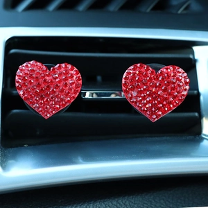 Detail of red rhinestone heart car air vent clips installed on dashboard vents