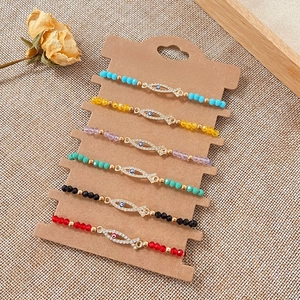 Detail of 6-piece beaded bracelets with rhinestone evil eye fish charms on card