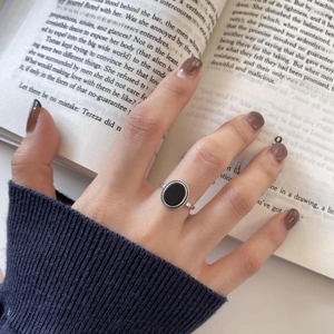 Detail of vintage 925 silver ring with black onyx stone worn while reading a book