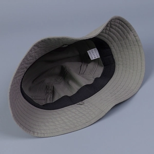 Détail de l'intérieur du chapeau de soleil montrant l'étiquette 100% polyester et le bandeau