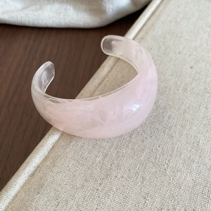 Macro detail of pale pink marble textured resin cuff bracelet with translucent finish