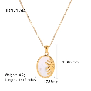 Detail of golden oval pendant with white shell inlay and sun design including dimensions