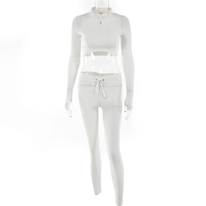 Close-up of white two-piece tracksuit featuring half-zip cropped top and high-waisted leggings