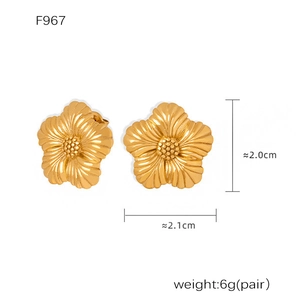 Detailed macro view of gold flower stud earrings showing size and petal texture
