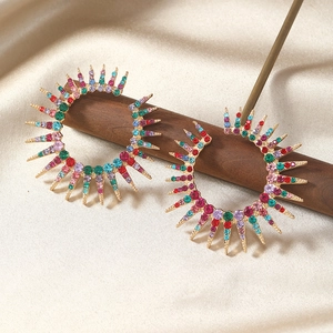 Close-up of multicolored rhinestone sunburst hoop earrings on elegant silk background