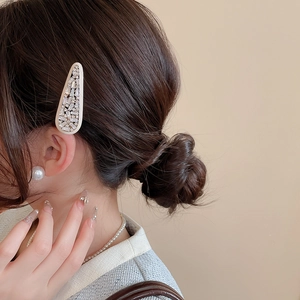Detail of teardrop hair clip with inlaid zircons on model with dark brown hair
