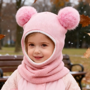 Pink toddler balaclava with dual faux fur pom-poms and thick fleece lining in outdoor setting