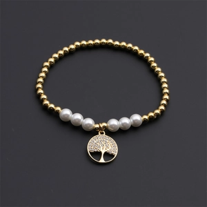 Elastic gold beaded bracelet with white pearls and a sparkling Tree of Life charm pendant