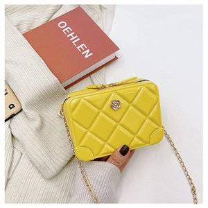 Detail of yellow PVC jelly bag with quilted diamond pattern and floral decoration