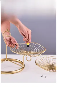 Detailed view of the easy assembly process for a gold 3-tier metal fruit basket structure