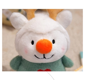 Close-up of soft reindeer plush toy with green outfit and red heart embroidery