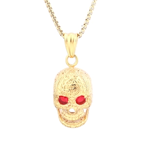 Detailed view of a gold skull pendant with red gemstone eyes and intricate metal carving