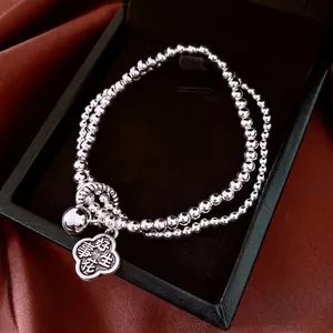 Double-layered beaded silver flower bracelet with bell and Good Fortune pendant