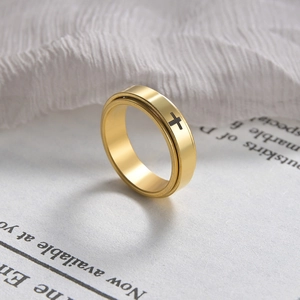 Detailed view of a golden spinning ring with black cross patterns on fabric background