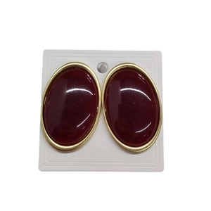 Vintage oval earrings in dark red resin with a matte gold metallic border on white card