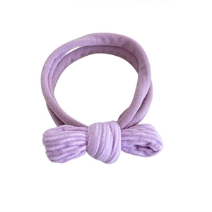 Purple corduroy baby headband with a minimalist bow design on white background
