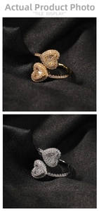 Detail of silver and gold heart rings with rectangle cut stones on black satin