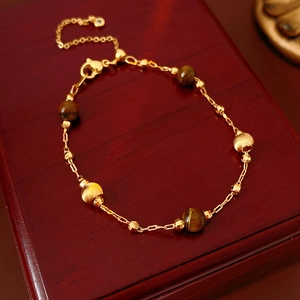 Detail of gold-plated tiger eye bracelet with round beads and lobster clasp closure