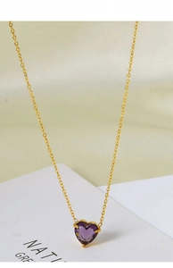 Macro detail of gold-plated titanium steel necklace with a purple heart-shaped zircon