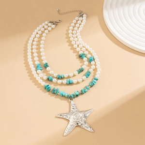 Close-up of bohemian layered necklace with large silver starfish and faux pearls