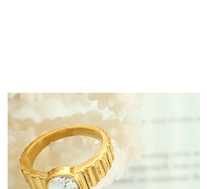 Macro shot of gold ring with vertical texture and a sparkling white round gemstone