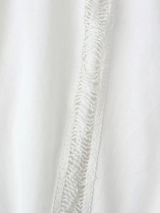 Gros plan de textile blanc avec couture de dentelle ajourée et texture de tissu en coton