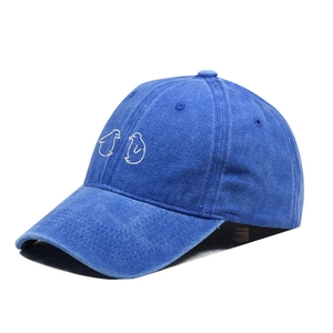 Detail van de schattige pinguïnborduursels op de marineblauwe katoenen baseballcap